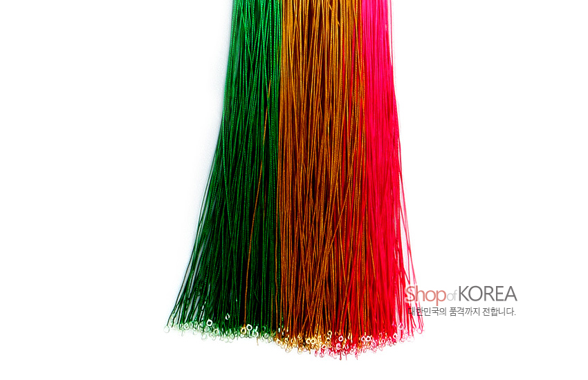 [텍스트: Shop of KOREA, 대한민국의 품격까지 전달합니다.] 녹색·황금색·홍색 실로 구성된 가는 합성섬유 술다발, 하단 은색 고리 장식 디테일 강조 이미지