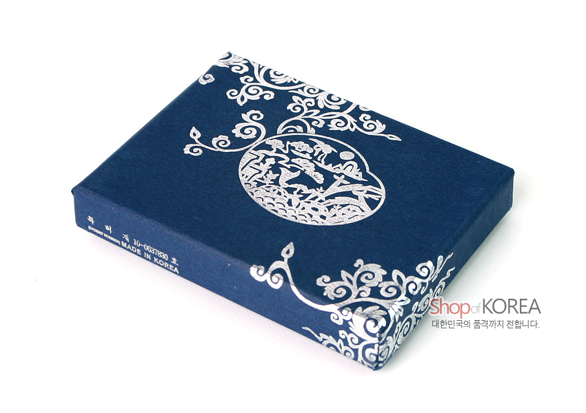 [텍스트: MADE IN KOREA] 짙은 남색 종이 재질 위 은색 수풀과 학 문양, 화려한 두루마기 형태의 장식 문양이 둘러진 직사각형 패키지 디자인