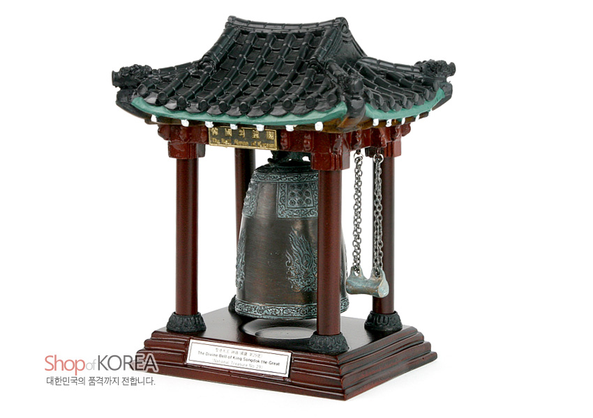 [텍스트: Shop of KOREA 대한민국의 품격까지 전합니다. The Divine Bell of King Seongdeok the Great National Treasure No. 29.] 청동빛 범종과 용무늬 부조, 적갈색 목조 기둥과 청록 기와지붕이 조화된 합성수지 전통 종각 모형 장식품