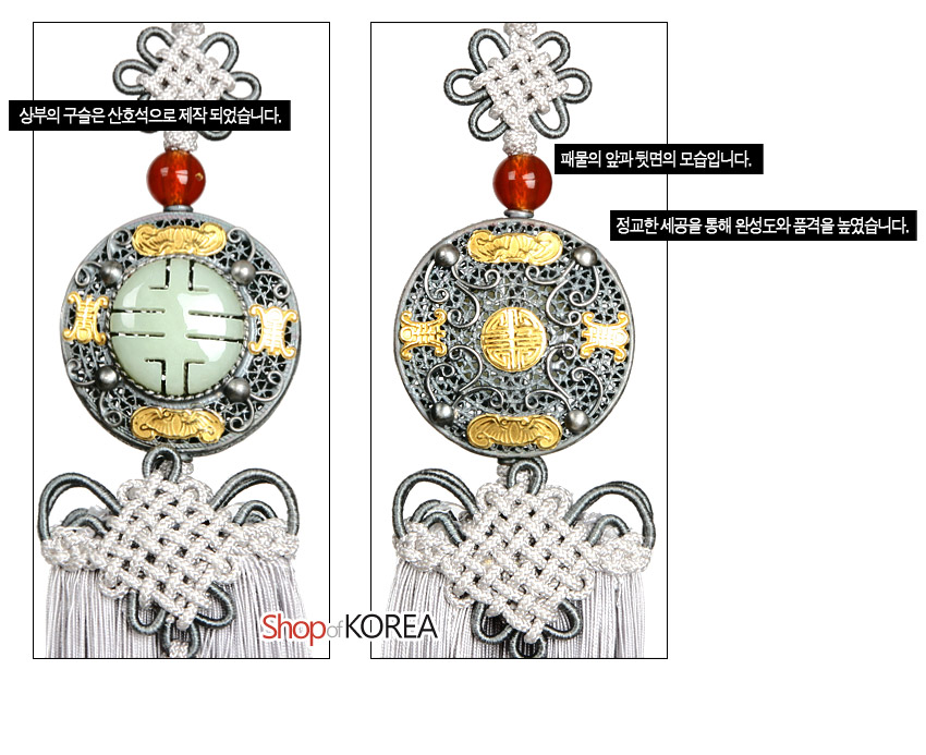 [텍스트: 상부의 구슬은 산호석으로 제작 되었습니다. 패물의 앞과 뒷면의 모습입니다. 정교한 세공을 통해 완성도와 품격을 높였습니다.] 옥과 금속으로 된 원형 패물에 박쥐·길상문양을 상감하고 산호 구슬, 회색 전통 매듭과 그라데이션 술이 조화를 이룬 노리개 장식