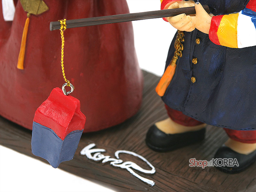 [텍스트: Shop of KOREA 대한민국의 품격까지 판매합니다] 채색 수지 재질 한복 인형 받침대와 붉은 치마, 남색 도포에 색동 소매, 금색 노리개 장식과 붉은·남색 청사초롱 매달린 모습의 근접 표현