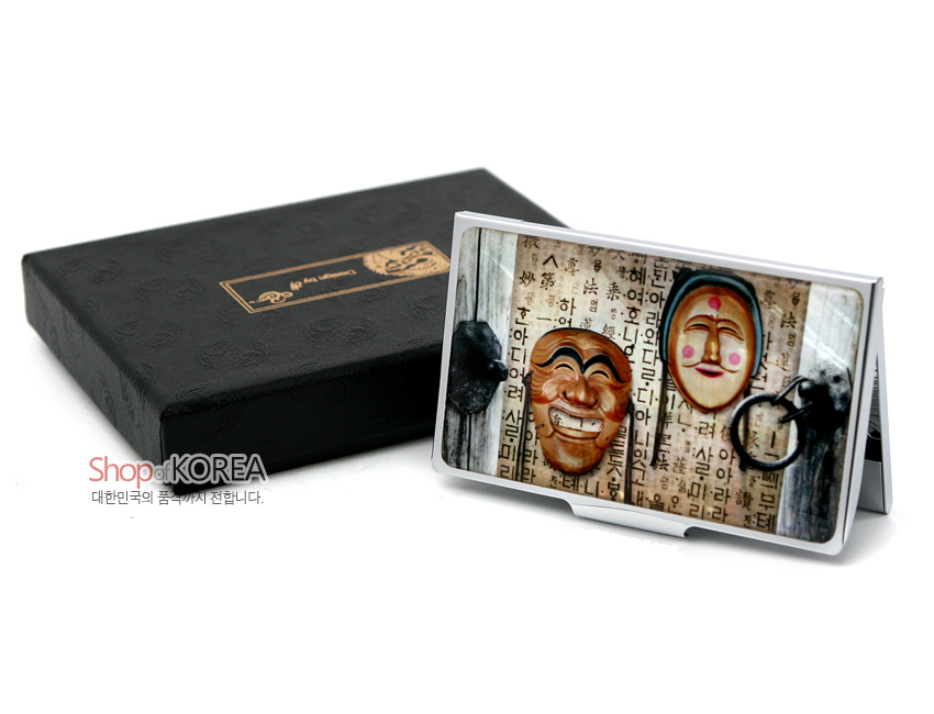 [텍스트: Shop of KOREA 대한민국의 품격까지 전합니다.] 금속 재질 위에 광택 코팅 처리된 표면, 한글 서체 배경과 목조 하회탈 문양을 인쇄한 직사각 명함집 디자인