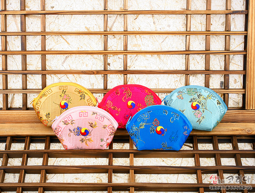 [텍스트: 샵오브코리아 대한민국의 혼과 정서가 전합니다] 비단 누비 원단에 태극 문양과 십장생·꽃·덩굴 자수 장식이 더해진 반원형 지퍼 동전지갑 여러 색상 배열 이미지