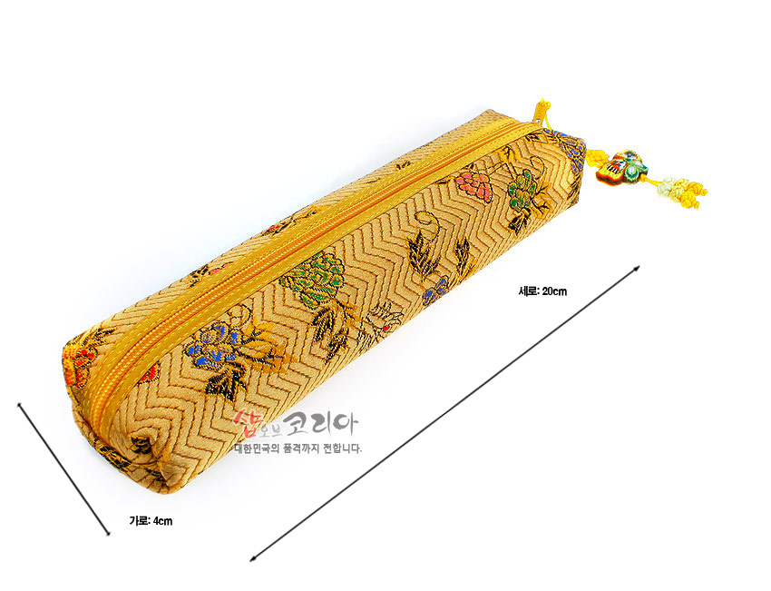 [텍스트: 세로: 20cm / 가로: 4cm / 샵오브코리아 대한민국의 품격까지 전합니다.] 금색 비단 누비 원단 위 지그재그 누빔 패턴과 다채로운 꽃 자수 문양, 색실 매듭 달린 지퍼 장식 필통 이미지 설명
