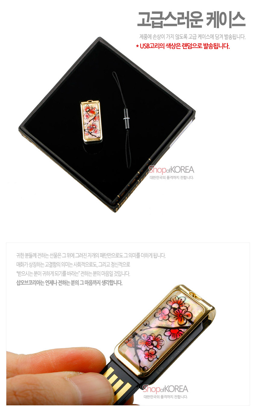 [텍스트: 고급스러운 케이스 / 제품에 손상이 가지 않도록 고급 케이스에 담겨 발송됩니다. / * USB고리의 색상은 랜덤으로 발송됩니다. / ShopofKOREA 대한민국의 품격까지 전합니다.] 자개 바탕 위 붉은 매화 가지 문양을 옻칠로 장식하고 금속 테두리로 마감한 USB 메모리 디자인