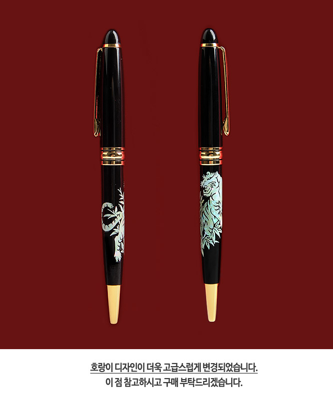 [텍스트: 호랑이 디자인이 더욱 고급스럽게 변경되었습니다. 이 점 참고하시고 구매 부탁드리겠습니다.] 검은 옻칠 바탕 위 자개 상감으로 표현된 호랑이와 식물 문양, 금속 골드장식이 조화를 이루는 고급 볼펜 디자인