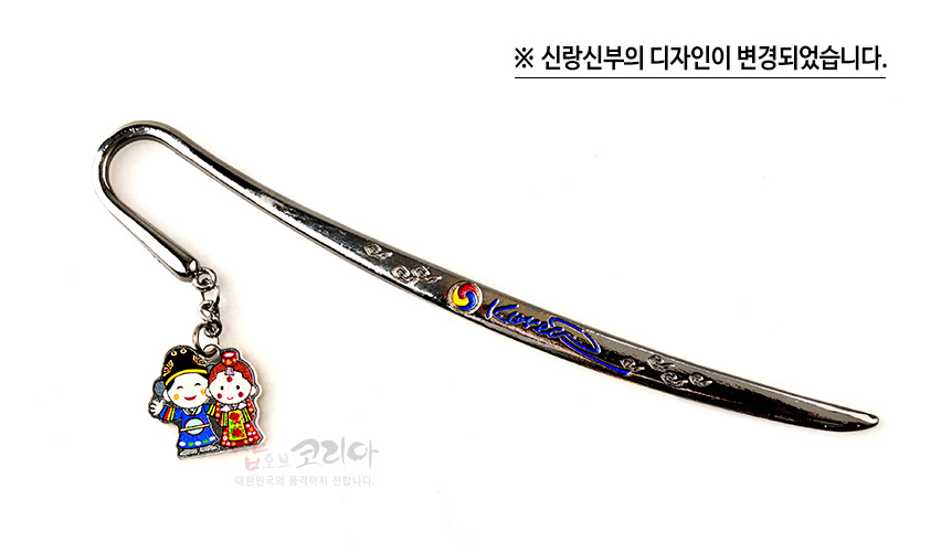 [텍스트: ※ 신랑신부의 디자인이 변경되었습니다.] 금속 재질 곡선형 책갈피에 태극 문양과 잎사귀 문양 양각, 색 에나멜 기법의 한복 입은 신랑신부 장식 매달림