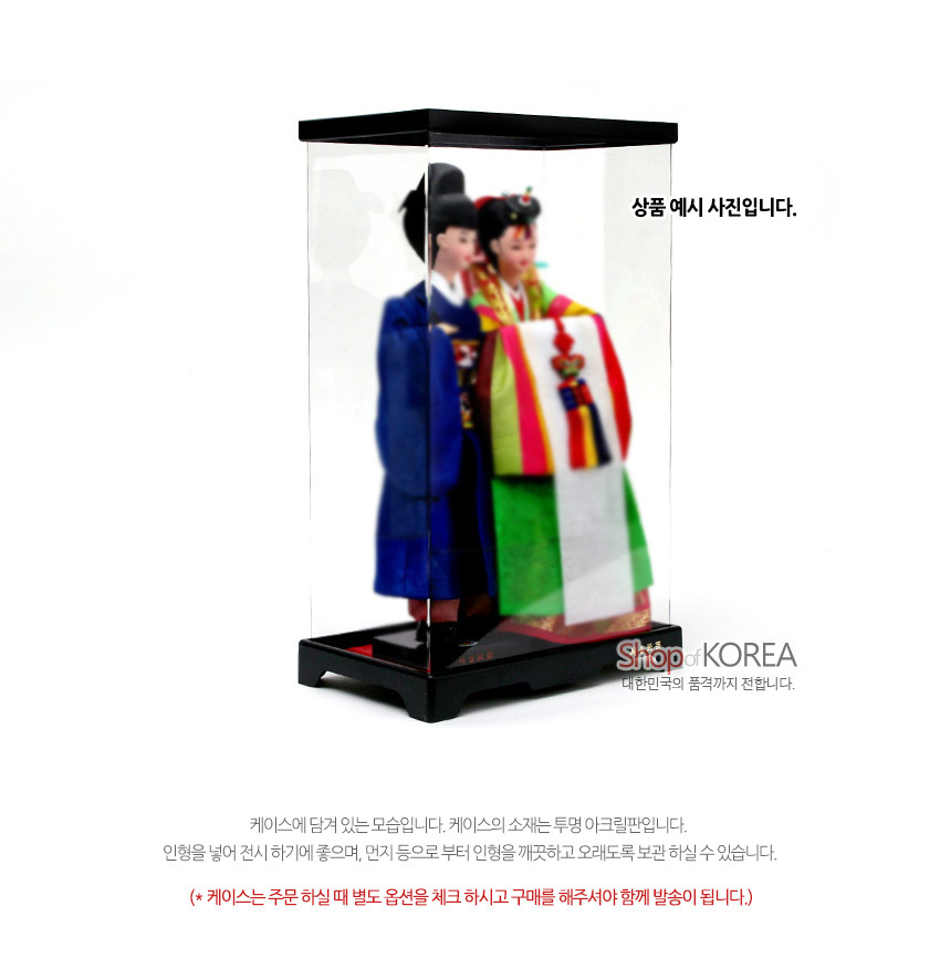 [텍스트: 상품 예시 사진입니다. / Shop of KOREA 대한민국의 품격까지 전합니다. / 케이스에 담겨 있는 모습입니다. 케이스의 소재는 투명 아크릴판입니다. 인형을 넣어 전시 하기에 좋으며, 먼지 등으로 부터 인형을 깨끗하고 오래도록 보관 하실 수 있습니다. (* 케이스는 주문 하실 때 별도 옵션을 체크 하시고 구매를 해주셔야 함께 발송이 됩니다.)] 투명 아크릴 케이스 안 전통혼례 한복인형 한 쌍, 오색 비단 장옷과 청색 도포, 장식 노리개가 어우러진 전통 공예 인형 연출
