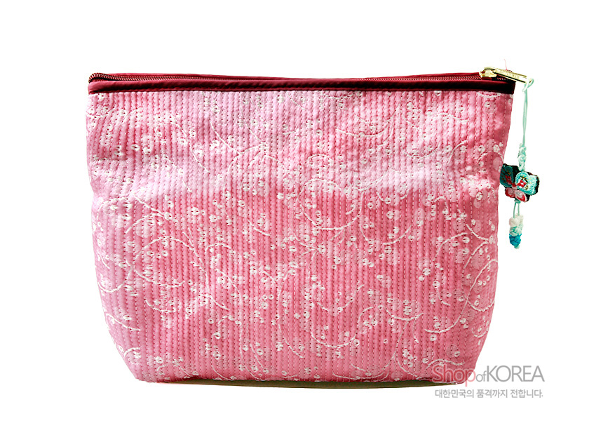 [텍스트: ShopKOREA 대한민국의 품격까지 전합니다.] 연분홍 누비 비단에 흰 꽃무늬 자수 장식, 윗부분 지퍼와 옆면 나비 모양 매듭 장식이 어우러진 파우치 지갑