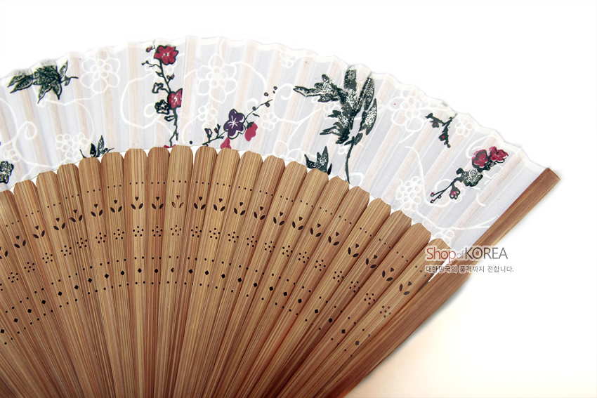 [텍스트: Shop of KOREA 대한민국의 품격까지 전합니다.] 흰 비단 면에 붉은 매화와 잎사귀 문양, 대나무살에 섬세한 타공 장식이 조화를 이룬 실크 수공 부채 이미지 설명