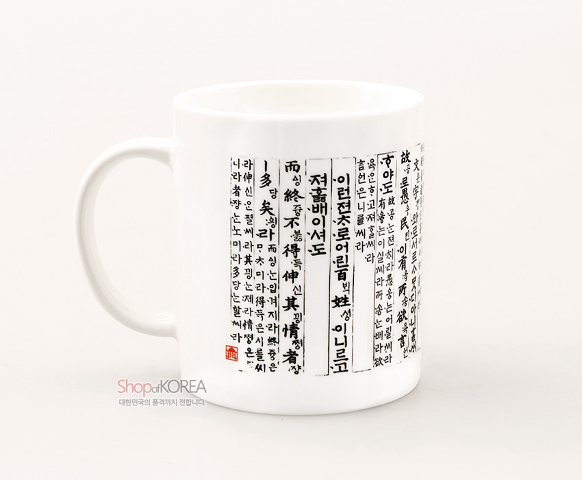 [텍스트: 나라의 말이 중국과 달라 문자와 서로 통하지 아니하므로 … ] 백색 도자 머그컵에 흑색 훈민정음 언해 세로 글자와 붉은 낙관을 배치한 전통 서체 디자인