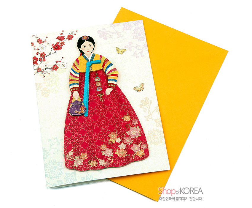 [텍스트: ShopofKOREA 대한민국의 품격까지 전합니다.] 색동 저고리와 붉은 치마의 한복 소녀, 금빛 꽃문양과 나비, 매화 가지가 어우러진 일러스트 카드 디자인