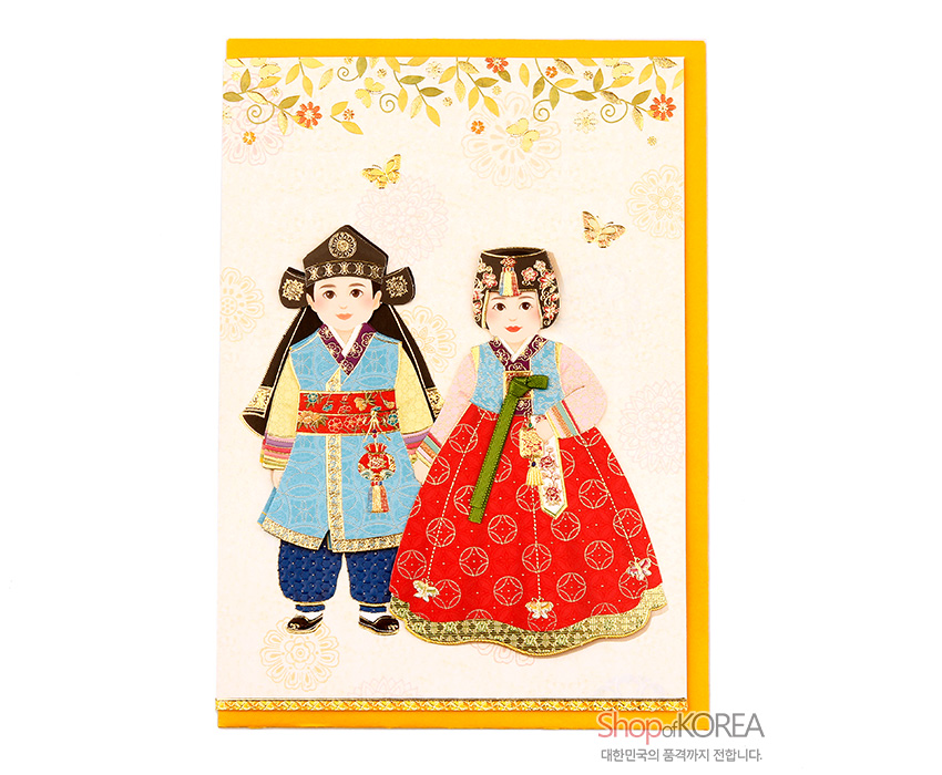 [텍스트: ShopofKOREA 대한민국의 품격까지 전합니다.] 금박 포인트와 화려한 꽃·나비 문양 배경 위 전통 한복 입은 소년소녀 양각 장식 카드, 붉은 치마와 청색 도포의 대비색 조화 표현