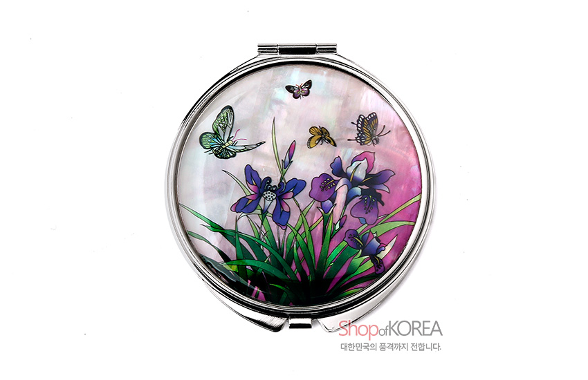 [텍스트: ShopofKOREA 대한민국의 품격까지 전합니다.] 분홍빛 자개 바탕 위에 상감 기법으로 표현된 붓꽃과 나비, 나방 문양이 화려하게 어우러진 원형 금속 손거울 디자인