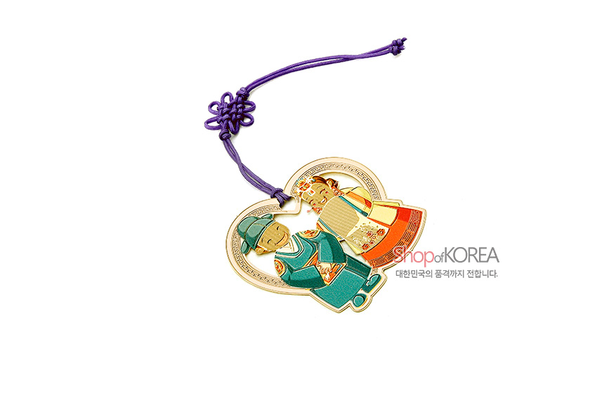 [텍스트: shop of KOREA, 대한민국의 품격까지 전합니다.] 금속 하트형 테두리에 전통 혼례복 신랑·신부 채색 문양과 보라색 매듭 끈 장식 책갈피 디자인