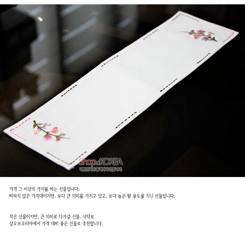 [텍스트: Shop of KOREA, 가격 그 이상의 가치를 하는 선물입니다. 비싸지 않은 가격대이지만, 보다 큰 의미를 가지고 있고, 보다 높은 활용도를 지닌 선물입니다. 작은 선물이지만, 큰 의미로 다가갈 선물. 식탁보. 샵오브코리아에서 가격 대비 좋은 선물로 추천합니다.] 광목 재질 화이트 식탁러너에 양 끝 분홍 매화 자수와 갈색 스티치 장식이 어우러진 디자인