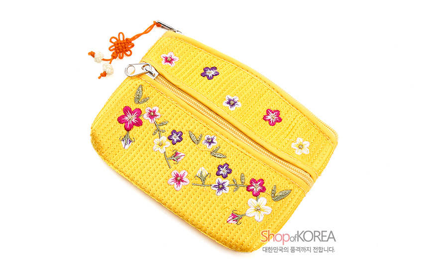 [텍스트: Shop of KOREA 대한민국 품격까지 전합니다.] 노란색 누비 천에 배꽃과 다양한 꽃문양 자수 장식, 금속 지퍼와 오렌지색 전통 매듭 장식 이중 지퍼 동전지갑 이미지 설명