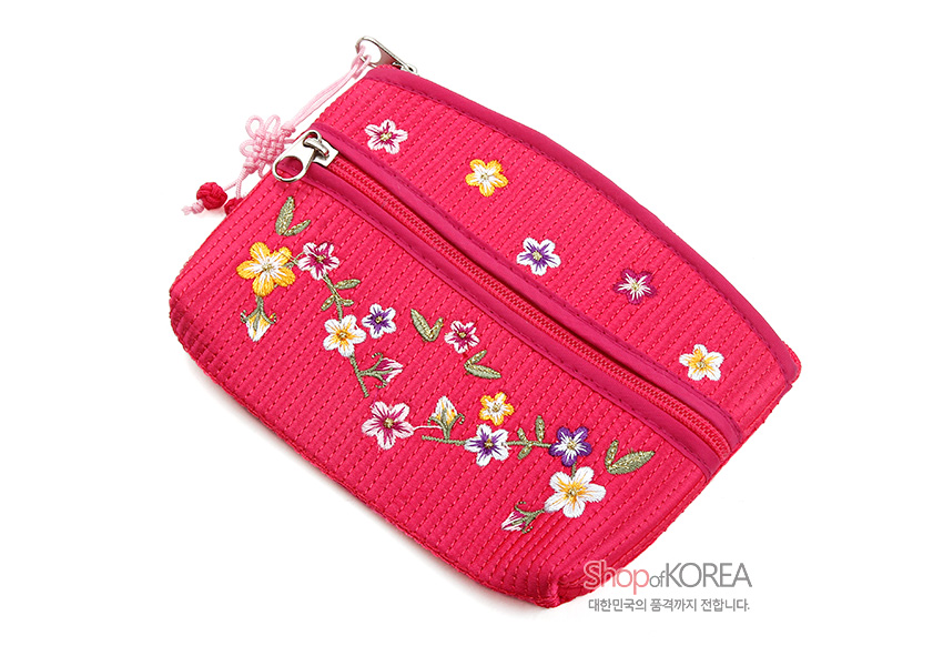 [텍스트: ShopofKOREA 대한민국의 품격까지 전합니다.] 분홍색 누비 원단에 다채로운 배꽃과 잎사귀 자수, 지퍼 장식과 매듭 포인트가 어우러진 동전지갑 디자인