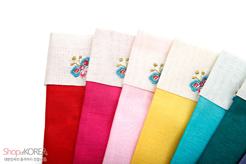 [텍스트: Shop of KOREA, 대한민국의 품격까지 전합니다] 다양한 색상의 비단으로 제작된 부채주머니, 흰색 배색 상단에 꽃자수 문양이 수놓인 전통 디자인