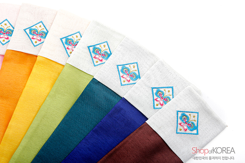 [텍스트: Shop of KOREA 대한민국의 품격까지 전합니다.] 오색 비단 재질의 부채주머니 상단에 흰색 천과 청색 선으로 둘러싼 나비 전통 자수 문양을 수놓은 디자인