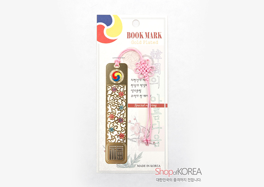 [텍스트: BOOK MARK, Gold Plated, Special writing, MADE IN KOREA] 금장 금속 재질에 당초문 음각과 칠보 색채 장식, 상단 태극 문양과 분홍 전통 매듭끈, 하단 복자 문양 구성