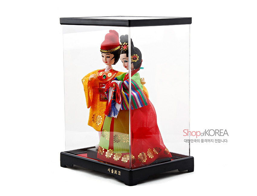 [텍스트: Shop of KOREA, 서울民藝] 투명 케이스 안 금박 꽃문양 장식 노랑 비단 왕관과 색동 소매·홍치마 비 인형, 매듭 노리개 포인트 전통 한복 인형 세트