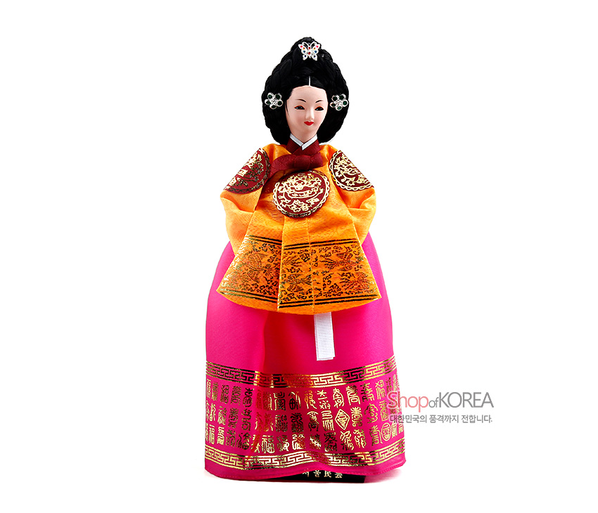 [텍스트: Shop of KOREA 대한민국의 품격까지 전합니다.] 분홍 치마와 금박 문자·길상문 띠 장식, 황금색 당의의 원형 보문 금박과 자수, 옥색 비녀·장신구 올린 궁중 한복 인형 모습