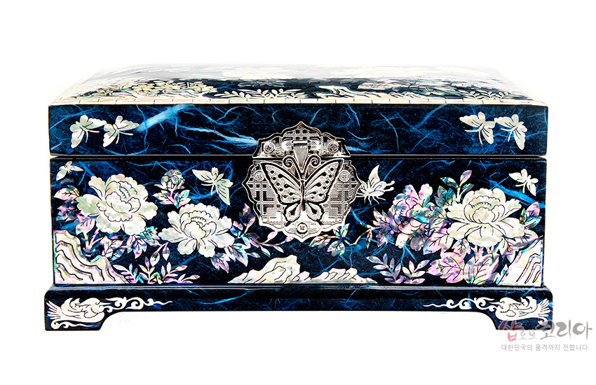 [텍스트: 샵오브코리아 대한민국의 품격까지 전합니다.] 짙은 청색 옻칠 바탕 위 자개 상감으로 목단과 나비, 연꽃문양을 섬세하게 장식한 직사각 보석함 디자인