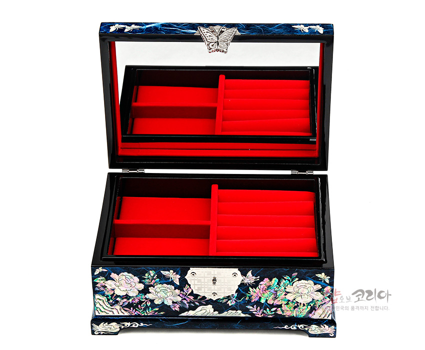 [텍스트: 샵오브코리아 대한민국의 품격까지 전합니다.] 짙은 청색 옻칠 위 자개 상감 목단과 나비 문양 장식, 내부 붉은 벨벳 칸막이와 뚜껑 거울로 구성된 직사각 보석함 이미지설명