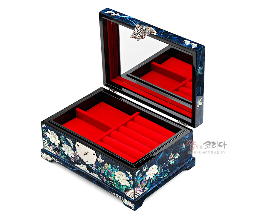 [텍스트: 샵오브코리아 대한민국의 품격까지 전합니다.] 짙은 청색 옻칠에 자개 상감으로 목단과 나비 문양을 장식하고 내부는 붉은 칸막이와 반지 고정대를 더한 직사각 보석함 이미지 설명