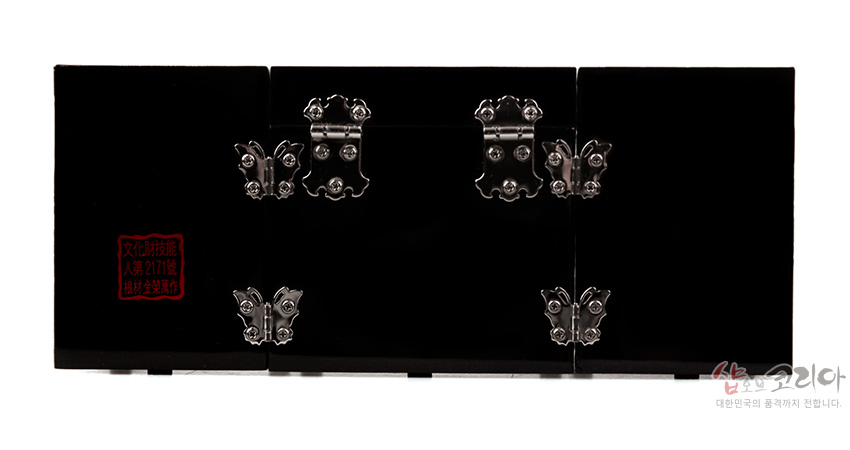 [텍스트: 文化財技藝 人第2171號 趙抒金製作] 흑색 옻칠 바탕에 은색 금속 경첩과 장식 철물을 단 3폭 쌍합보석함 후면 모습