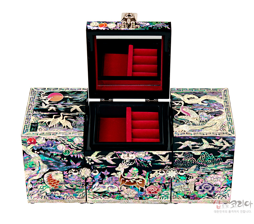 [텍스트: 샵오브코리아 대한민국의 품격까지 전합니다.] 흑색 옻칠 위 자개 상감 기법으로 학·사슴·거북·송백·해·구름과 모란을 화려한 색채로 장식한 3폭 쌍합 보석함 내부 붉은 비단 장식 구조 모습