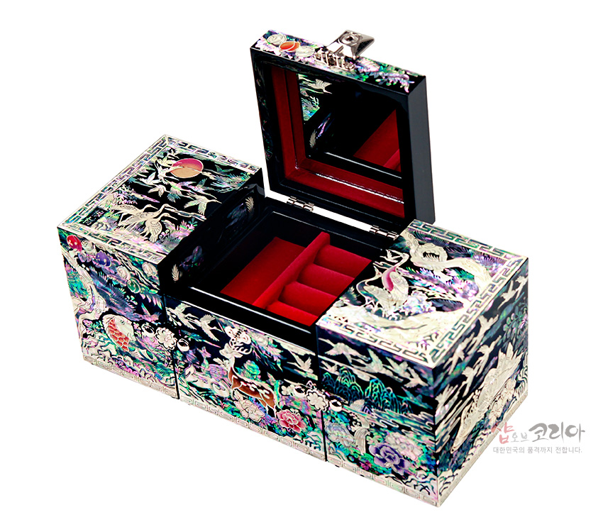 [텍스트: 샵오브코리아 대한민국의 품격까지 전합니다.] 흑색 옻칠 바탕에 자개 상감 기법으로 학과 해·구름·산수·꽃문양을 화려하게 장식하고 내부는 붉은 벨벳과 거울로 마감한 3폭 쌍합 보석함 이미지 설명