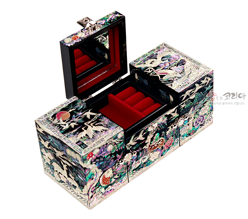 [텍스트: 샵오브코리아] 흑색 옻칠 위 자개 상감 기법으로 장생도와 학, 구름, 해, 송학문을 화려하게 담고 내부는 붉은 벨벳으로 마감한 3폭 쌍합 보석함 이미지 설명