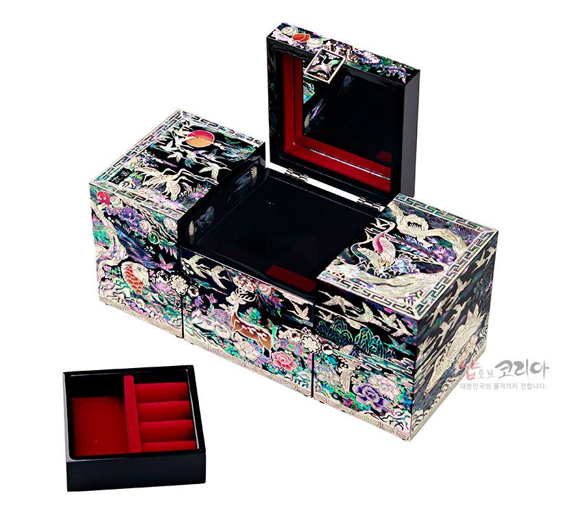 [텍스트: 샵오브코리아 대한민국의 품격까지 전합니다.] 흑색 옻칠 위 오색 자개 상감 기법으로 장생도, 학, 사슴, 소나무, 해와 구름 문양을 정교하게 장식한 3폭 쌍합 보석함과 붉은 비단 내부 트레이 구성