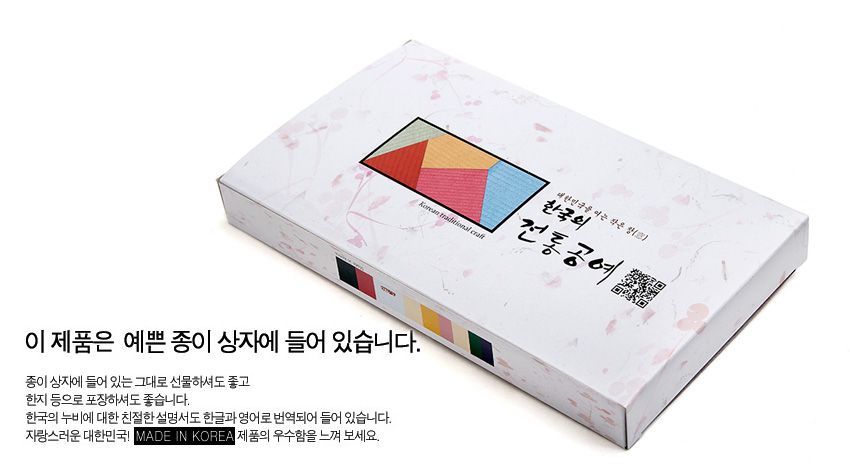 [텍스트: 이 제품은 예쁜 종이 상자에 들어 있습니다 / 한국의 누비 / 행복의 전통공예 / MADE IN KOREA] 한지 질감의 백색 종이 상자 위에 오방색 조각보 패턴을 인쇄한 직사각형 패키지 디자인
