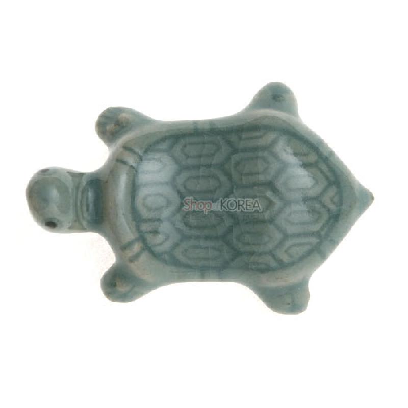 청자 재질에 옅은 비취색 유약을 입히고 거북 등껍질 기하학 문양을 새긴 수저받침.