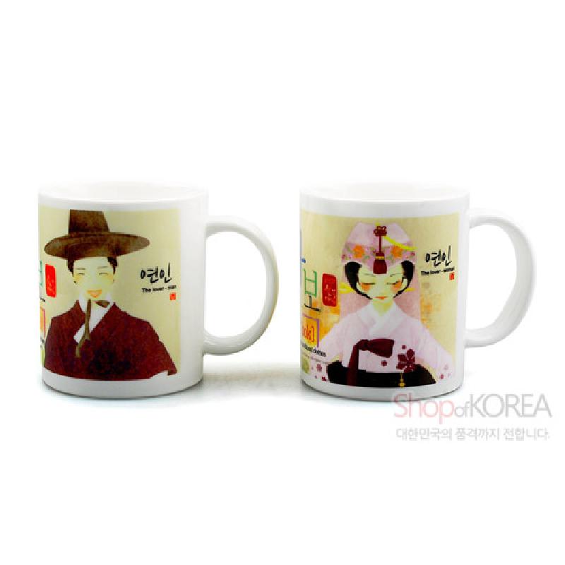 한복 차림 남녀 일러스트와 한글 서체가 인쇄된 백색 도자기 머그컵 세트.