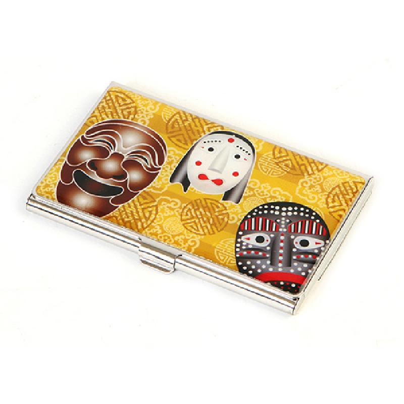 금속 재질 위 노랑 바탕에 한국 전통 탈 문양을 화려한 색감으로 인쇄한 명함집. 금속 재질 위 노랑 바탕에 한국 전통 탈 문양을 화려한 색감으로 인쇄한 명함집.