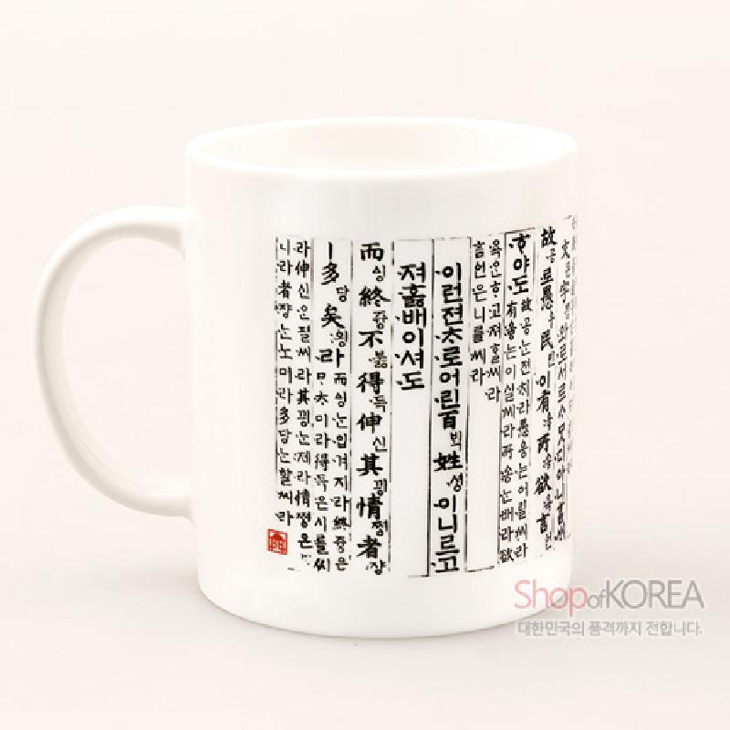 흰색 도자기로 제작된 머그컵에 검정색 훈민정음 언해 서체와 붉은 낙관이 둘러진 디자인.
