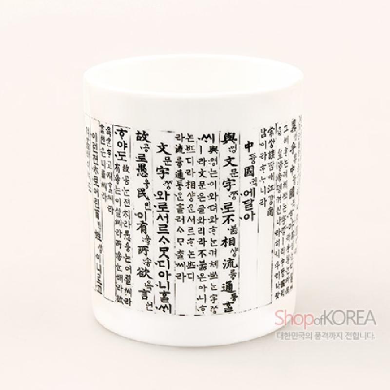 백색 세라믹 재질에 훈민정음 언해 한글·한자 서체를 흑색으로 가득 인쇄한 머그컵.