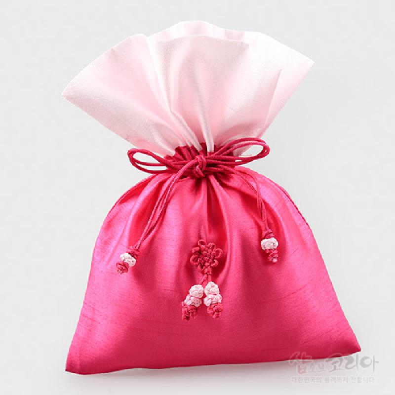 진분홍색 비단 재질에 흰색 대비 상단, 전면에 전통 매듭 장식이 더해진 복주머니형 주머니.