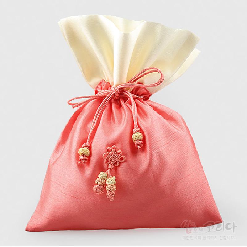 담주색과 아이보리 비단으로 제작된 복주머니형 주머니, 앞면 꽃 매듭 장식과 색실 매듭 술이 특징인 전통 매듭주머니.