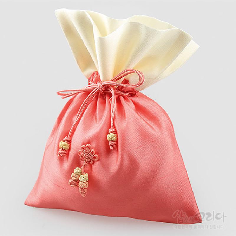 담주색 비단 천으로 제작된 주머니에 연아이보리색 안감과 끈 매듭, 꽃 모양 매듭 장식이 돋보이는 전통 매듭주머니.