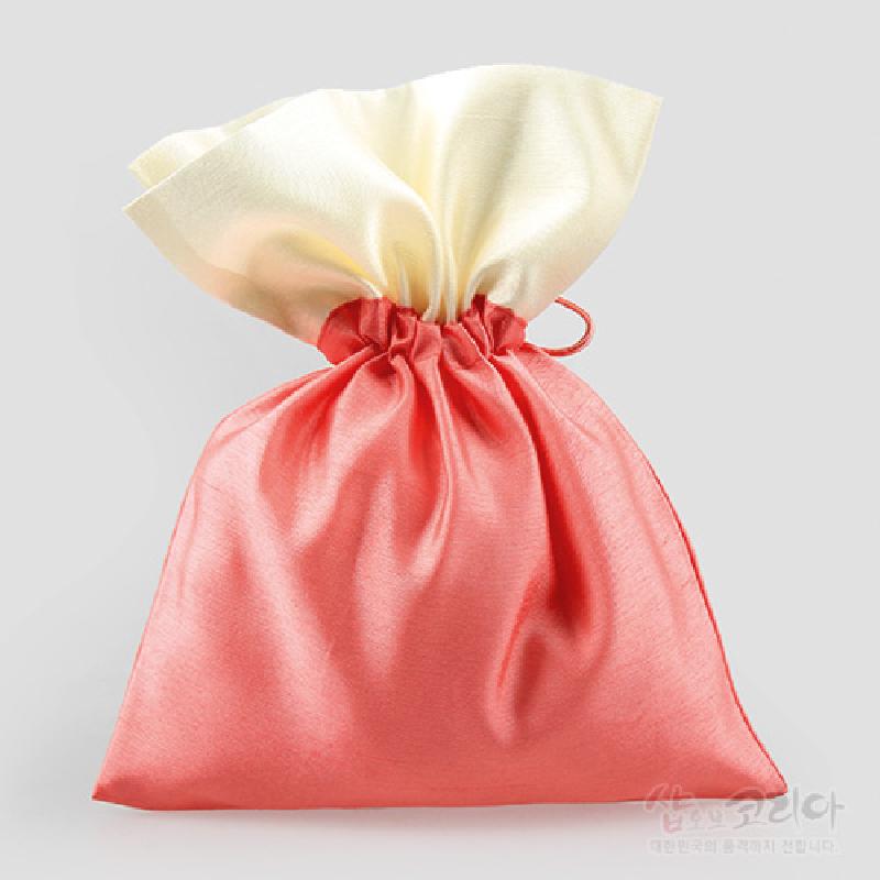 담주색과 아이보리 색상의 배색이 돋보이는 비단 재질 끈 매듭주머니.