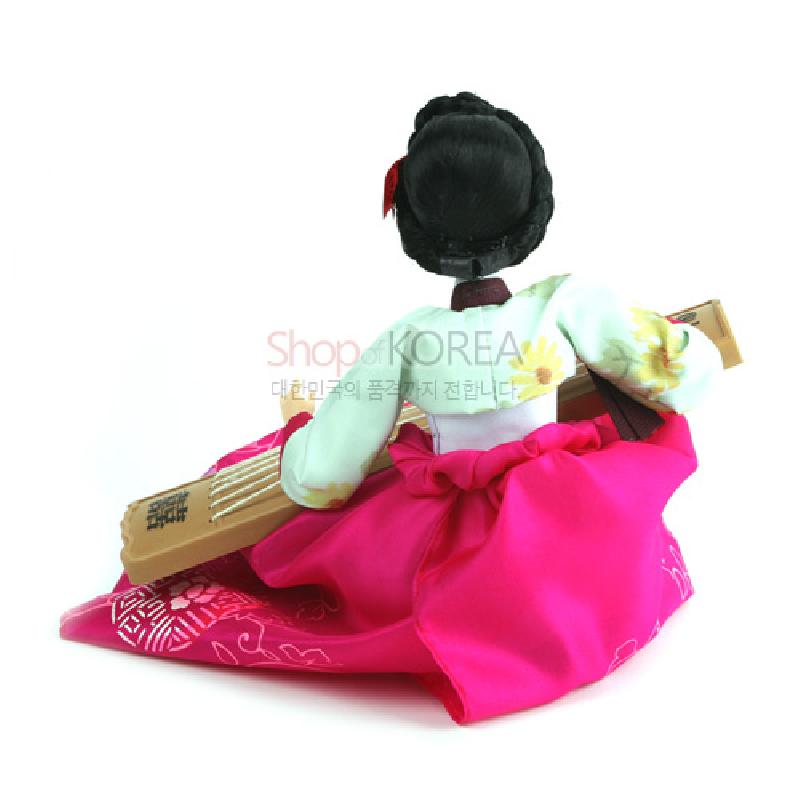 분홍색 치마와 연두색 꽃문양 저고리를 입고 가야금을 안은 전통 한복인형 장식.