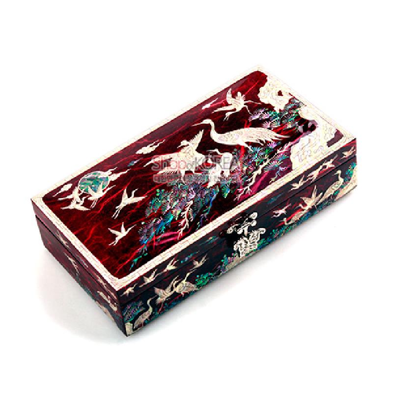 붉은 한지 바탕 위 자개 상감으로 송학과 소나무 문양을 장식한 직사각형 보석함.