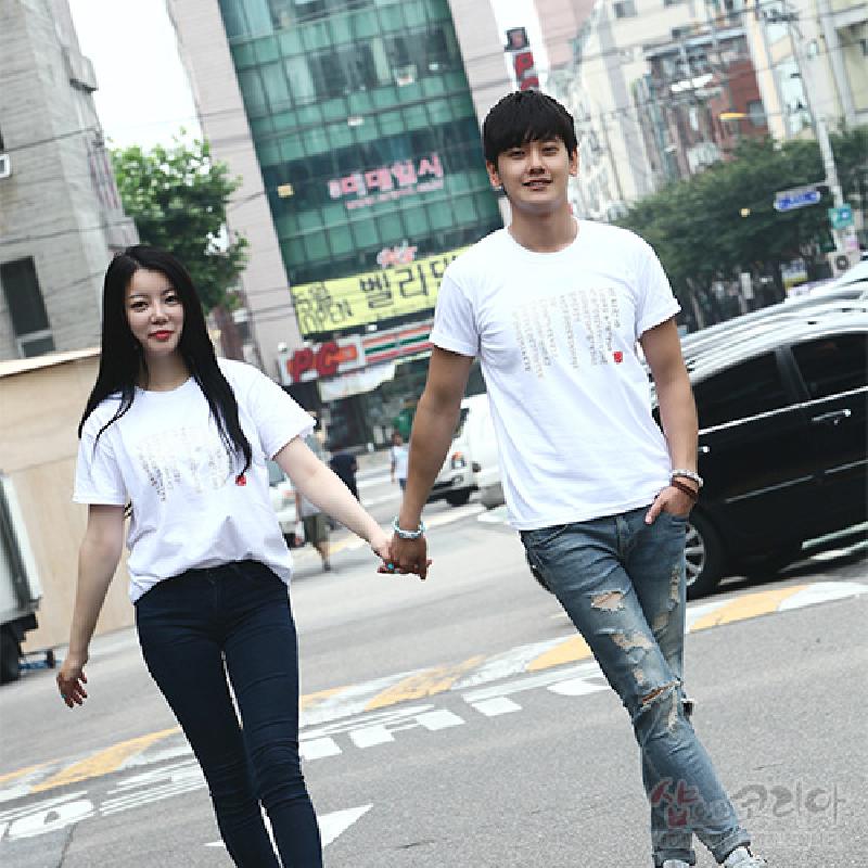 흰색 면 소재에 금빛 입체발포 기법으로 훈민정음 서체 문양이 새겨진 반소매 티셔츠. 흰색 면 소재에 금빛 입체발포 기법으로 훈민정음 서체 문양이 새겨진 반소매 티셔츠.