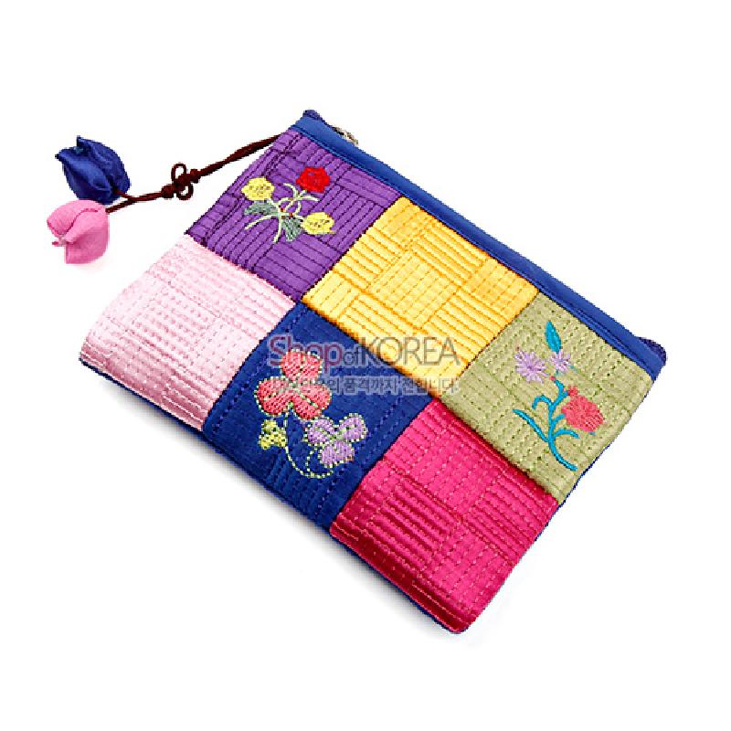 비단 소재 누비 기법으로 구성된 오방색 조각 패턴과 꽃 자수 문양, 매듭 장식이 달린 지퍼형 동전지갑. 비단 소재 누비 기법으로 구성된 오방색 조각 패턴과 꽃 자수 문양, 매듭 장식이 달린 지퍼형 동전지갑.