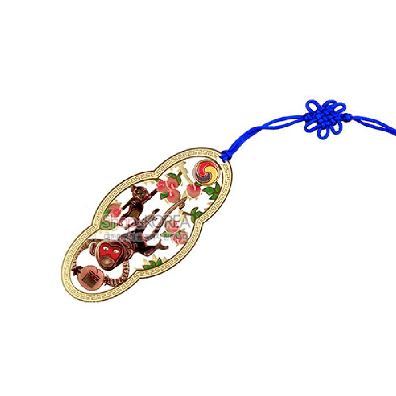 금장 금속 테두리에 원숭이와 복숭아, 태극 문양을 채색한 책갈피와 청색 전통 매듭 끈 장식. 금장 금속 테두리에 원숭이와 복숭아, 태극 문양을 채색한 책갈피와 청색 전통 매듭 끈 장식.